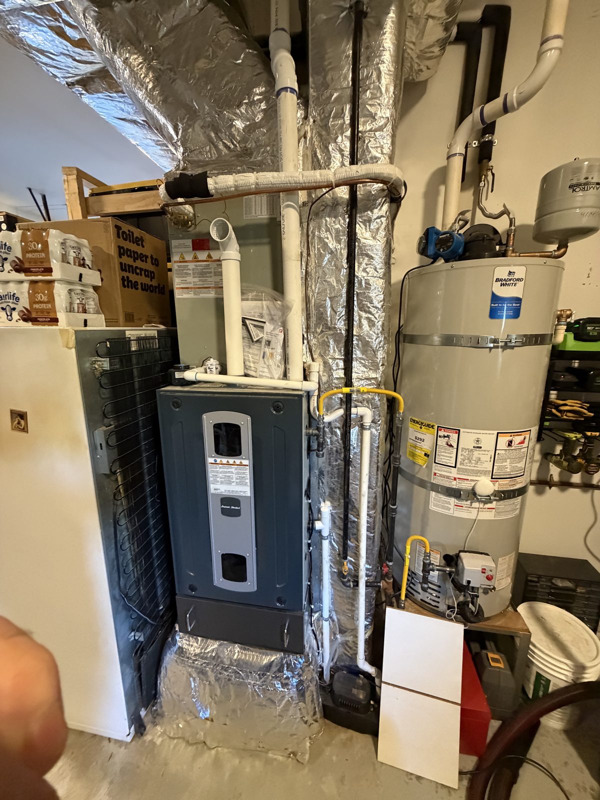 High-efficiency furnace installed next to a water heater in a basement